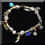 J073. Silver charm bracelet. Some charms signed Misani and Pageo. 7.5” - $28